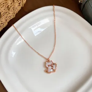 Close-up detail of a rose gold cat pendant necklace with elegant white shell inlay