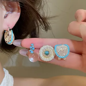 Detailed view of vintage zircon earrings featuring turquoise beads and hollow floral patterns