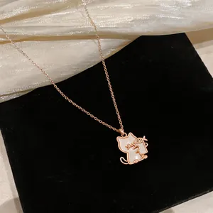 Close-up detail of a rose gold cat pendant necklace with elegant shell inlay and fish bone