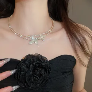 Close-up detail of a luxury double-layer silver necklace with sparkling diamond flowers.
