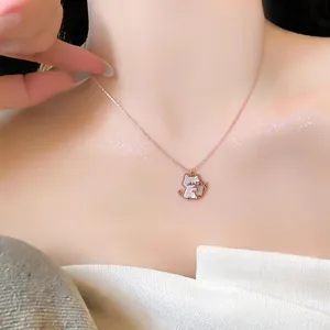 Detailed view of a rose gold cat pendant necklace with white shell inlay worn by a model