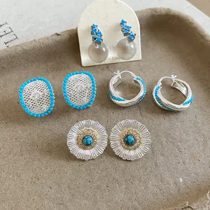 Detailed view of vintage silver earrings with turquoise beads and intricate sunflower design.