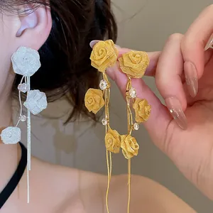 Detail view showing delicate mesh rose design and flowing tassels on elegant earrings