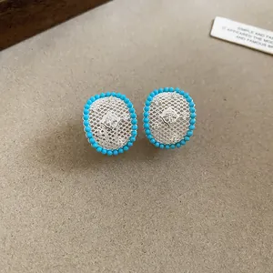 Detailed view of vintage silver lace stud earrings with turquoise beads and zircon