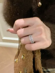 Nahaufnahme eines silbernen Zirkonia-Spitzenrings, getragen mit einem braunen Pullover