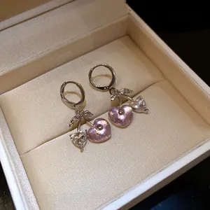 Close-up of pink resin heart and crystal cherry pendant hoop earrings in gift box