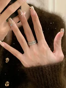 Detailansicht eines Zirkon-Spitzenrings am Finger, die feine Handwerkskunst zeigt.
