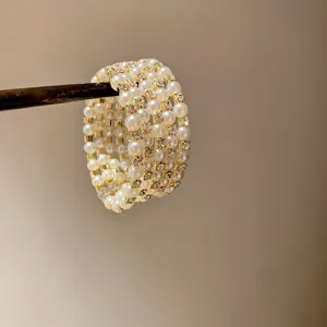Close-up of multi-layer gold ring with pearls and sparkling rhinestones
