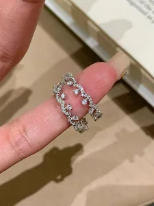 Nahaufnahme eines eleganten Zirkonia-Spitzenrings mit Blumendesign am Finger