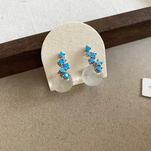 Close-up detail of retro turquoise stone cluster earrings with frosted translucent bead drop