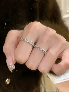 Nahaufnahme eines eleganten silberfarbenen Zirkon-Spitzenrings, der am Finger getragen wird.