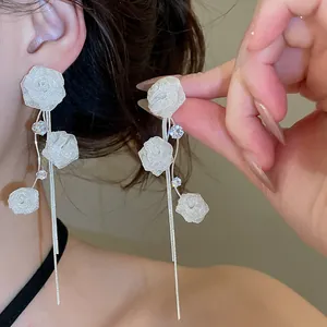 Detail view of French mesh rose tassel earrings with delicate silver chains