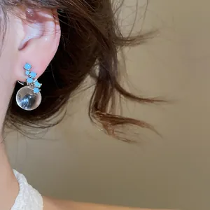 Close-up of vintage Buccellati style earring with turquoise stones and clear glass ball