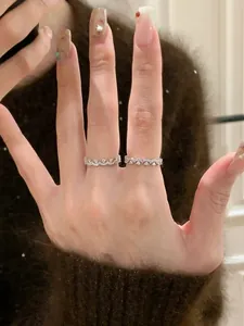 Detailansicht eleganter silberner Spitzenringe mit funkelnden Zirkonien auf Hand