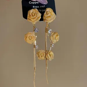 Detail view of elegant golden mesh rose tassel earrings with sparkling rhinestone accents