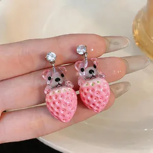 Primer plano de aretes de oso fresa de resina con circonitas brillantes y dulces