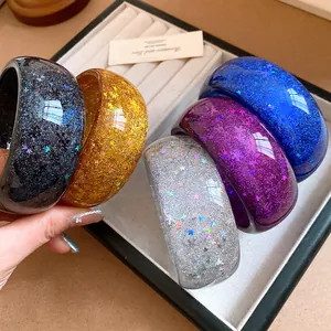 Detailed view of colorful resin bangles with glitter stars and snowflakes inside