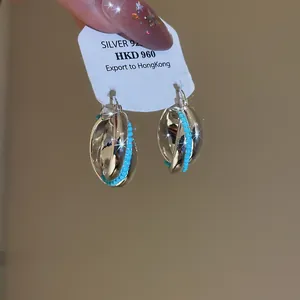 Close-up detail of vintage style twisted metallic hoop earrings with turquoise beads