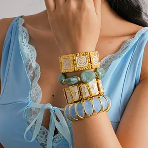 Close-up of stacked European style metal bracelets with star and resin details