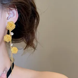 Elegant close-up view of gold mesh rose tassel earrings worn by a model in a lifestyle setting
