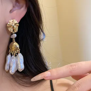 Close-up detail of vintage baroque pearl drop earrings with elegant gold metal finish
