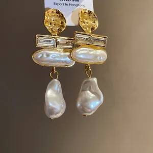 Close-up of vintage baroque pearl earrings featuring gold-tone metal and crystal details