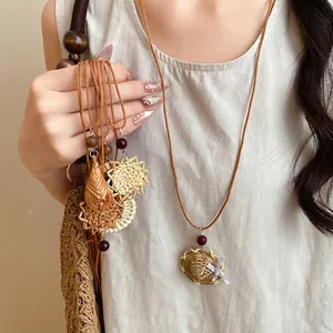 Collier bohème en rotin tressé à la main avec pendentif fleur, cordon cuir et perles bois