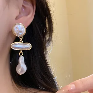 Close-up detail of vintage baroque pearl drop earrings with elegant gold-tone accents