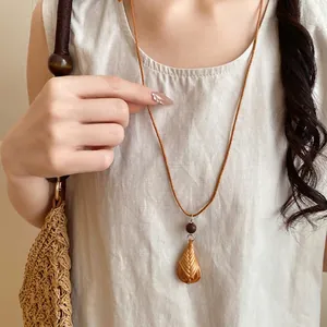 Collier bohème fait main avec pendentif fleur tissée, cordon en cuir et perle en bois
