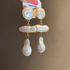 Close-up of vintage Baroque pearl drop earrings with elegant gold accents.