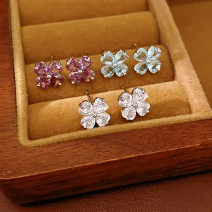 Detail of zircon clover stud earrings in purple, blue, and white in a jewelry box.