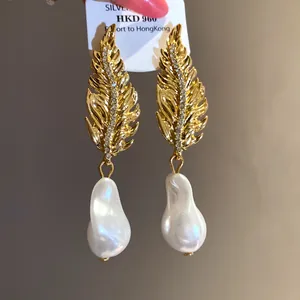 Elegant vintage gold leaf earrings featuring baroque pearls and sparkling crystal details.