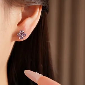 Detailed close-up of a silver needle clover stud earring featuring purple heart-shaped zircons