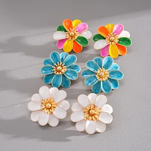 Detailed view of vibrant colorful drip oil flower stud earrings with gold centers