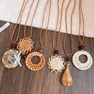 Gros plan de pendentifs bohèmes en rotin tressé avec perles en bois sur cordons en cuir