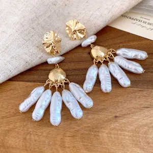 Detailed close-up of vintage baroque pearl drop earrings with textured gold-tone metal studs