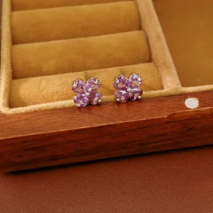 Close-up detail of elegant purple zircon four-leaf clover earrings in a box