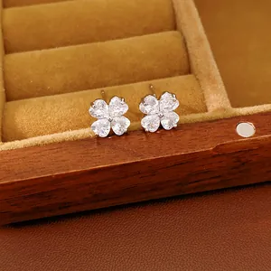 Detailed shot of sparkling four-leaf clover stud earrings set with heart-shaped crystals