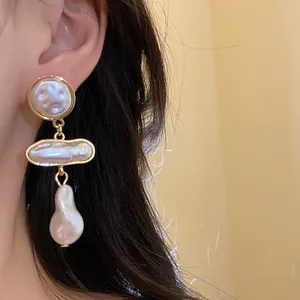 Detailed view of vintage baroque pearl drop earrings with gold-tone accents for women.