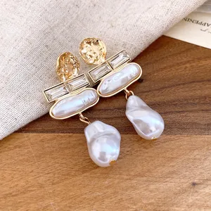 Macro view of vintage Baroque pearl earrings featuring hammered gold and crystal accents