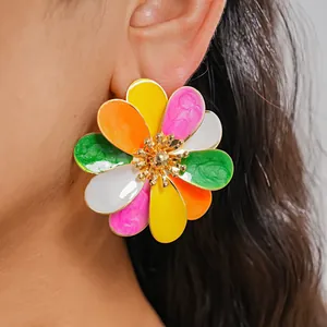 Close-up detail of a vibrant enamel flower earring with colorful petals worn on an ear