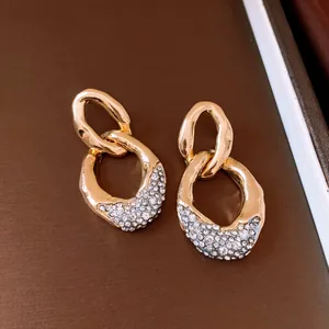 Primer plano detallado de elegantes pendientes bañados en oro con pavé de cristales