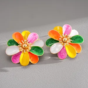 Detailed macro view of colorful enamel flower stud earrings in vibrant dopamine styles