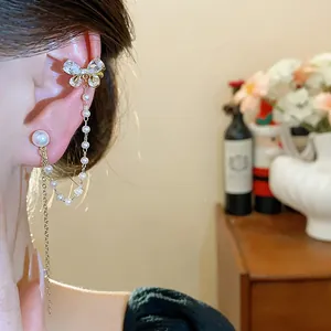 Dettaglio dell'ear cuff a farfalla placcato oro 18 carats con nappa a catena di perle