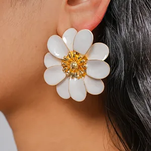 Close-up detail of white enamel flower stud earring with gold center