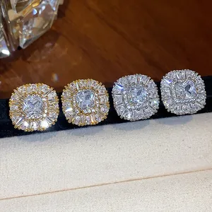 Primo piano di orecchini a lobo quadrati con zirconi in oro e argento, design halo