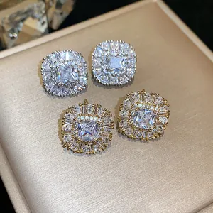 Dettaglio ravvicinato di orecchini quadrati in zirconia con finiture argento e oro