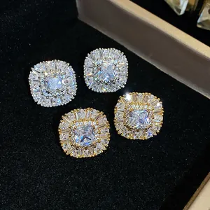 Dettaglio macro di eleganti orecchini a lobo quadrati in zircone argento e oro in scatola