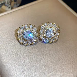 Dettaglio di orecchini a lobo quadrati in zircone scintillante con placcatura oro.
