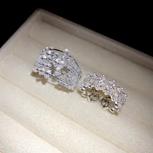 Detailed macro view of sparkling zircon and white pearl open rings in a velvet box